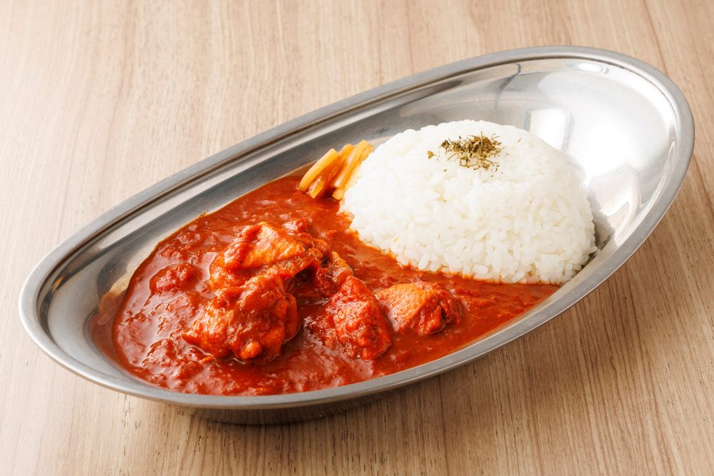 銀の皿に盛った国産地鶏のトマトチキンカレー